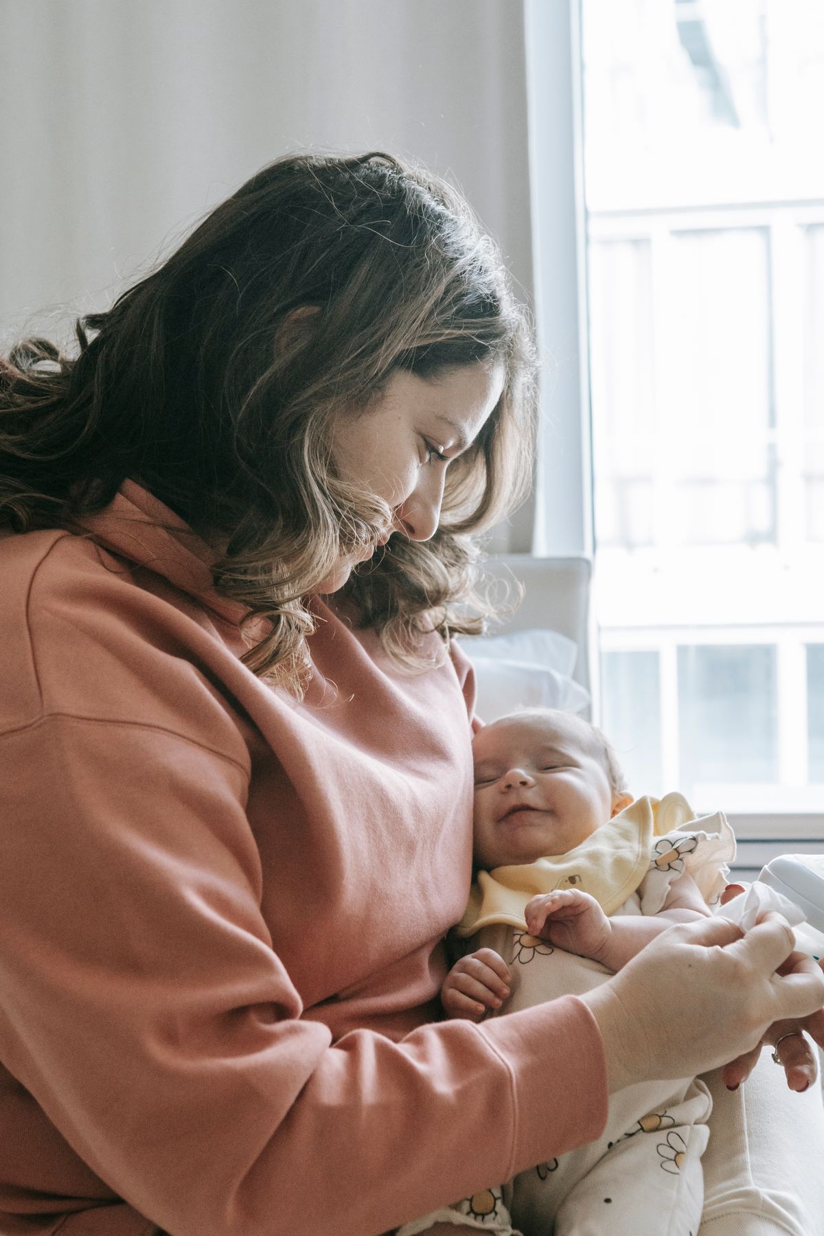 A mother holding her baby at home, illustrating nurturing care