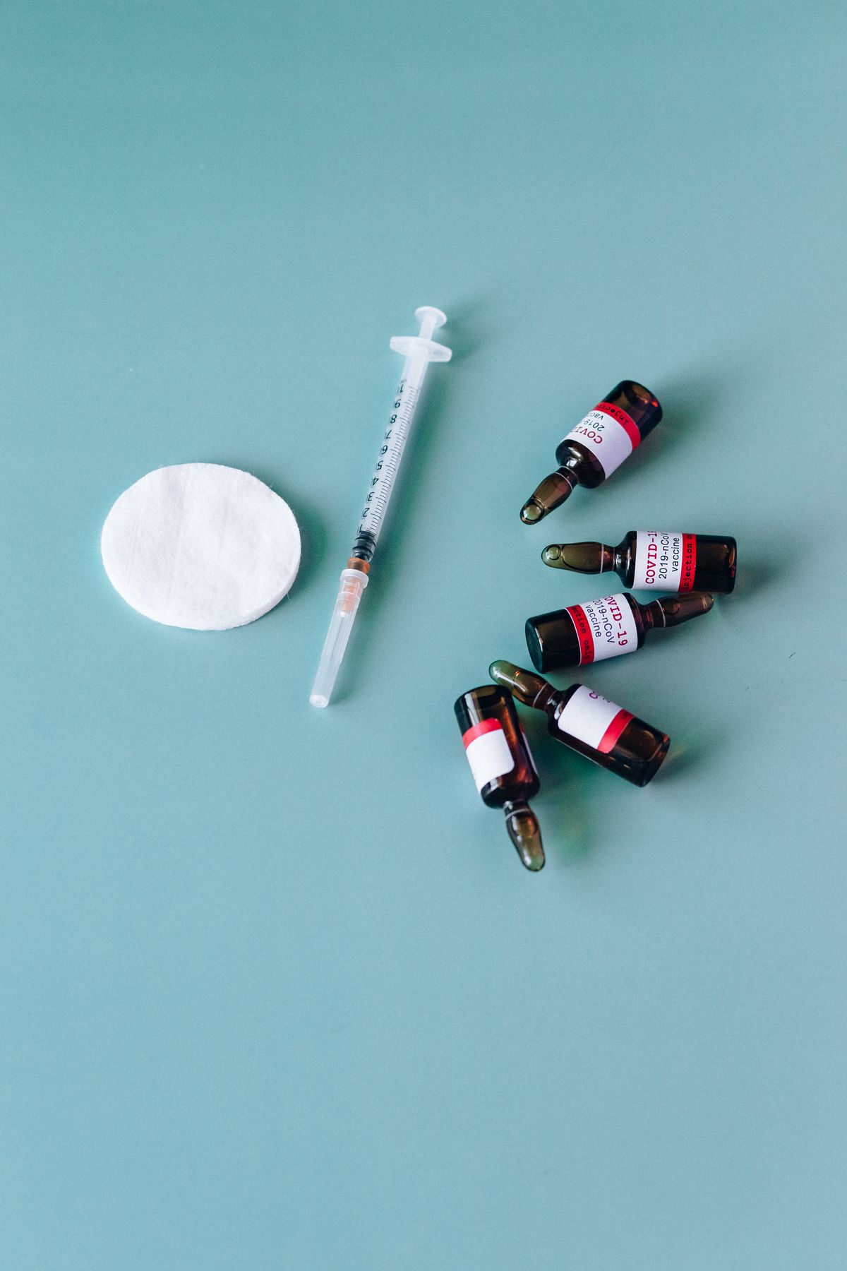 Vaccine vials and a syringe, illustrating vaccination supplies and logistics